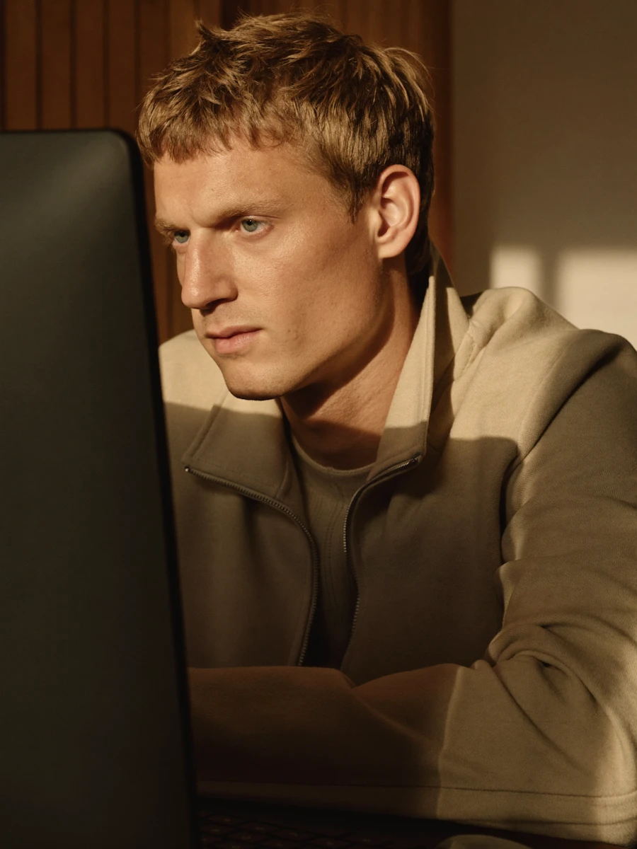 A man studying his screen in warm afternoon light.